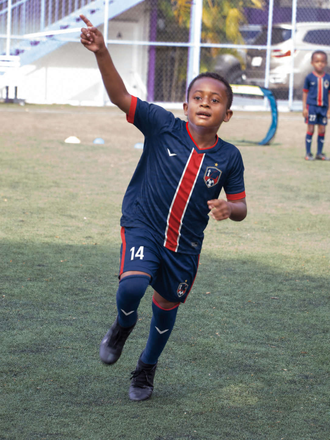 Young player in Frères kit sprinting during a training session